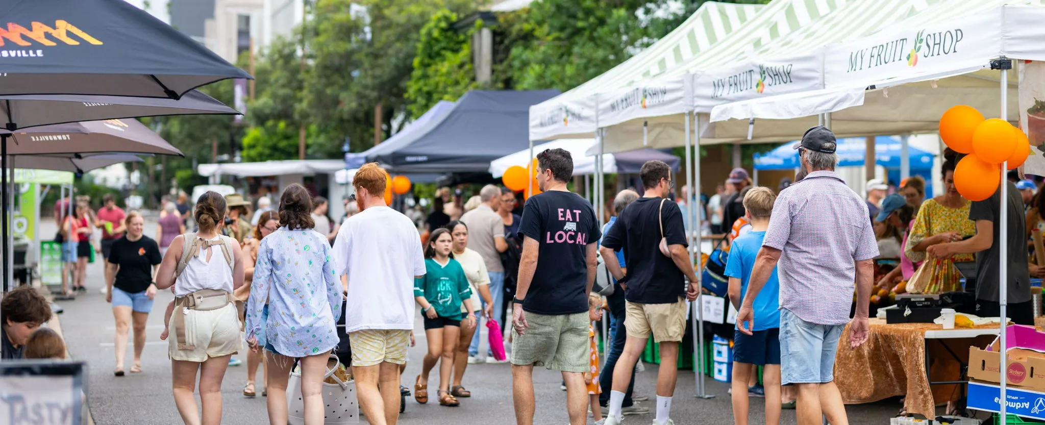 Crowds on market day outside fruit stand
